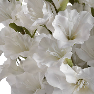 Dense cluster of open white artificial gladioli flowers, highlighting the fabric texture.