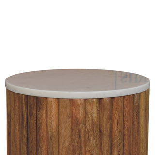 Close view of the smooth white marble tabletop surface resting on the textured vertical wooden fluting.