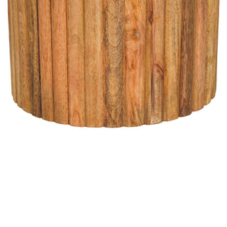 Detail showing the scalloped bottom edge of the wooden fluted base and the rich natural wood grain.