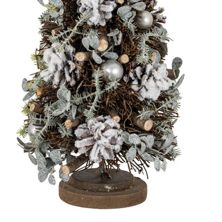 Close-up of the frosted tree decorations, including pinecones, silver pearls, and the rustic wooden base.