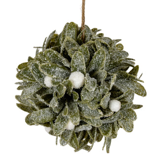 Close view of the dense green leaves and white berries, heavily dusted with fine white glitter.