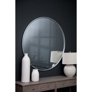 Tall and short white vases displayed together on a console table, reflected in a large round mirror above.