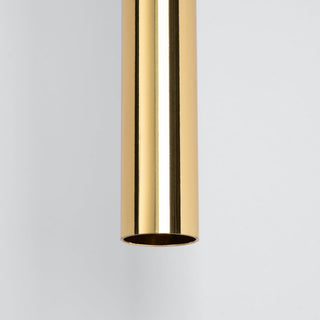 Close detail of the cylindrical gold pendant light showing the highly polished reflective finish.