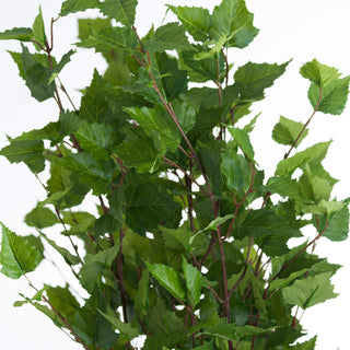 Tight close-up showing the dense arrangement of artificial green serrated leaves and thin reddish-brown stems.
