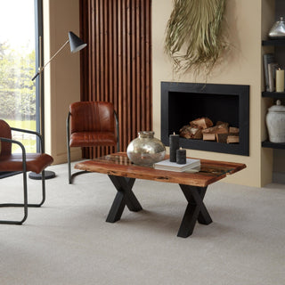 Large dried green palm arrangement hanging loosely above a black fireplace opening.