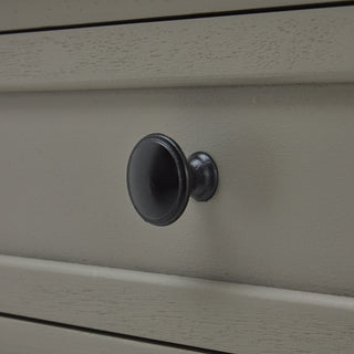 Close-up of the grey wood drawer front, highlighting the brushed texture and the round, dark metal knob handle.