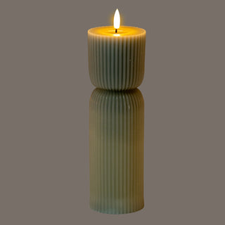 Grey carved LED candle illuminated, showing the vertical fluting texture and warm faux flame.