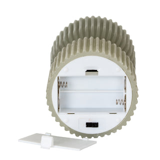 Underside of the grey LED candle showing the battery compartment and power switch.