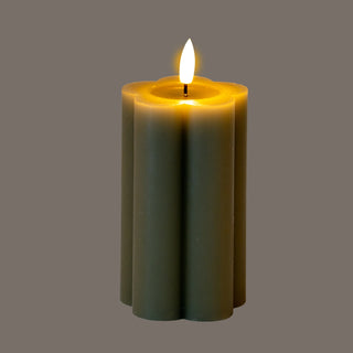 Fluted grey LED pillar candle with artificial flame lit, showing the glowing top section.