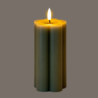 Grey fluted LED candle illuminated, highlighting the faux melted top and bright flickering flame.