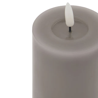 Detail shot of the grey flameless candle top, highlighting the wax texture and the plastic flame mechanism.