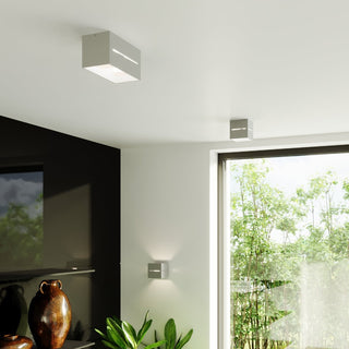 Grey aluminium lamps used as wall uplighter, large ceiling spotlight, and small ceiling spotlight.