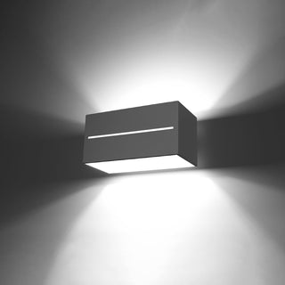 Grey aluminium wall lamp illuminated, highlighting the narrow front slit and the strong up and down light beams.