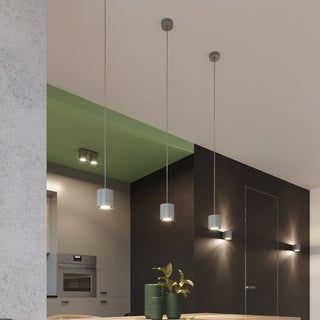 Modern kitchen scene with multiple grey cylindrical pendant lights and a twin spotlight fixture.