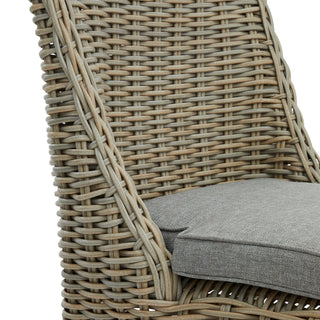 Woven texture detail of the grey rattan chair back and the thick grey seat cushion.