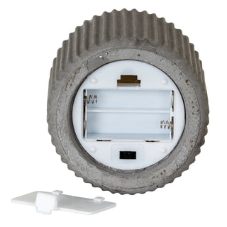 Detail of the candle base showing the empty battery compartment, switch, and detached cover.