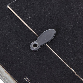 Detail of the frame's back, showing a black plastic swivel clip securing the black felt backing board.