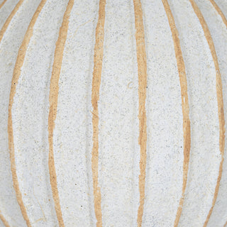 Extreme close-up showing the rough, speckled off-white texture and contrasting tan vertical grooves.