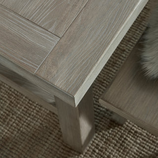 Corner detail of the dining table top, highlighting the light wood finish, visible grain, and thick square leg.