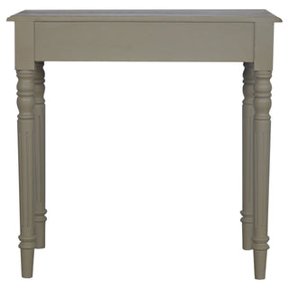 Straight-on view of the taupe writing desk showing the drawer panel and four turned, fluted legs.
