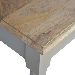 Corner detail showing the natural wood grain of the top and the taupe painted desk leg.