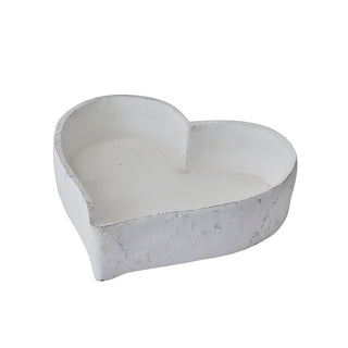 One matt white heart-shaped ceramic dish, viewed from above, showing the rough exterior and smooth interior.