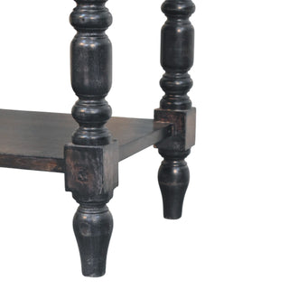 Detail of the dark wood turned legs and lower shelf joint, showing the distressed finish.