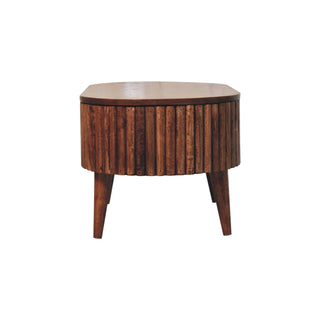 Full view of the oval coffee table in honey caramel finish, showing the ribbed body and tapered legs.