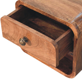 Close-up showing the drawer pulled open, revealing the interior storage space and the open slot beneath.