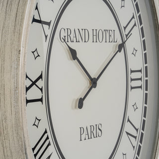 Close-up of the clock face, showing the Grand Hotel Paris text, black hands, and the heavily distressed grey frame.
