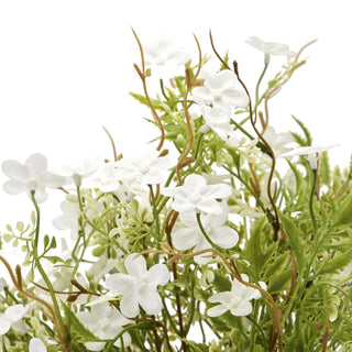 Close-up detail of the artificial white bellflower heads, showing the green leaves and brown winding stems.