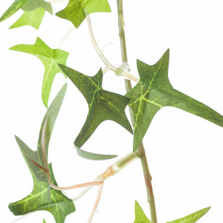 Detail of the plastic ivy garland showing the main stem and small root-like tendrils.