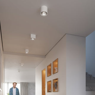 Multiple cylindrical and square ceramic ceiling lights installed along a modern hallway.