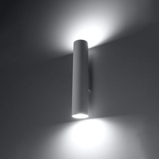 White cylindrical wall lamp demonstrating up and down light wash effect on a dark wall.
