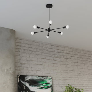 Black six-light chandelier installed above a grey brick wall and curved concrete column.