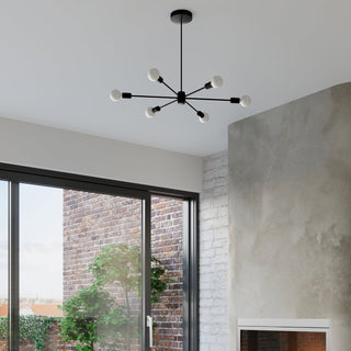 Black six-light chandelier installed in a modern interior with concrete walls and glass sliding doors.