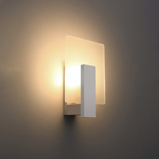 White wall lamp illuminated, highlighting the soft, warm light cast onto the surrounding wall surface.