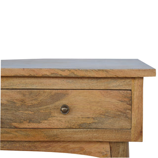 Tight crop showing the junction of the console tabletop and the top drawer face with a brass knob.