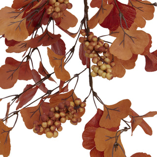 Detailed view of the autumn spray, showing the reddish-orange fabric leaves and pale yellow berry clusters.
