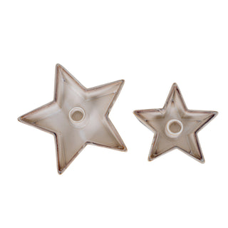 Two empty ceramic star candle holders, large and small, showing the size difference and speckled glaze.
