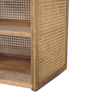 Detail of the mango wood frame, lower shelf, and woven cane webbing on the side and back panels.