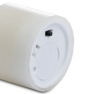 Close up of the base of the white LED candle, showing the battery compartment cover and black on/off switch.