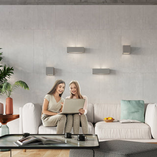 Lounge scene showing four grey ceramic wall lights installed in a decorative arrangement above a sofa.