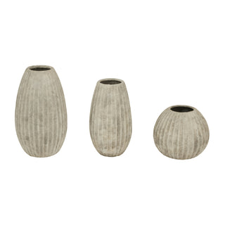 Three light grey ceramic vases of different sizes and shapes, all featuring vertical fluting.