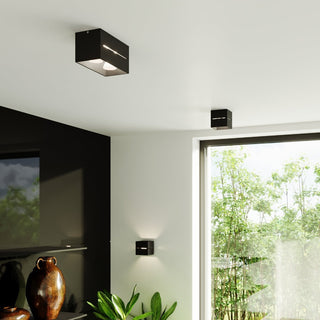 Black rectangular and square ceiling lights, plus a matching square wall light, in a contemporary interior.