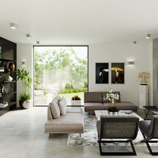 Modern living room scene showing two wall lamps illuminating artwork and two lamps flanking a large window.