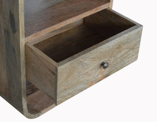 Close-up of the bedside table drawer partially open, showing the internal construction and metal knob.