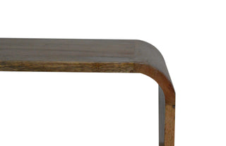 Close-up detail of the smooth, curved corner joint of the mango wood bedside table.