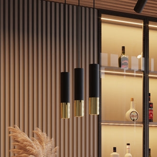 Trio of black and golden pendant lights hanging against a slatted wall, highlighting the ribbed texture of the golden base.