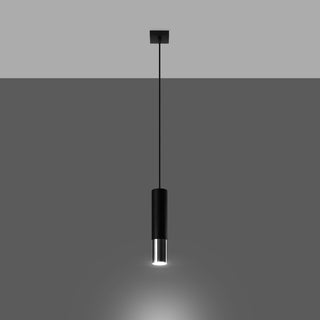 Matte black cylindrical pendant light hanging, illuminated to show the downward focused beam.